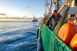 © Natalia - A fishing crew works on deck, securing nets and gear as their boat sails across calm ocean waters