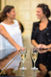 © auremar - Closeup of two champagne flutes, women in background