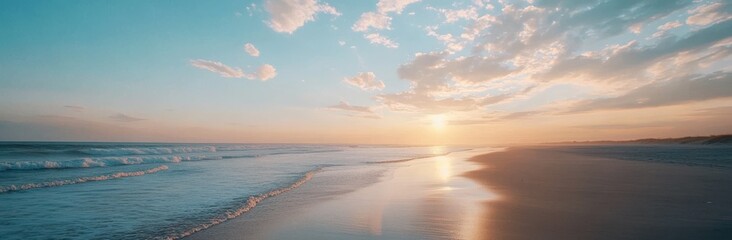 The ocean is calm and the sky is a beautiful shade of blue. The sun is setting, casting a warm glow over the water. The beach is empty, with no one in sight. The scene is peaceful and serene