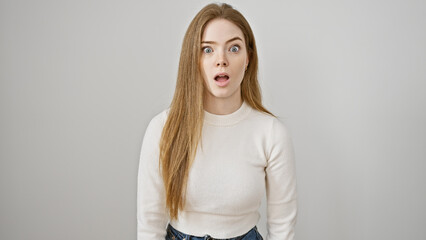 Wall Mural - Surprised young caucasian woman with long blonde hair against a white background.