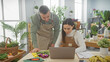 © Krakenimages.com - A man and woman in aprons use a laptop in a florist shop surrounded by plants and flowers, representing teamwork in a small business.