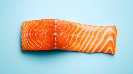 A fresh, raw salmon fillet with rich orange color and marbled fat, isolated on a light blue background, leaving space for text on the sides