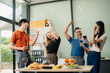 © laddawan - Young Asian Friends Celebrating with Laughter and Food at a Modern Evening Party
