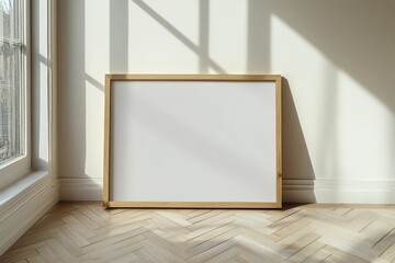 A simple, modern scene of a wooden-framed blank canvas lying on a light wood chevron