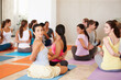 © Leffy/peopleimages.com - Stretching, yoga and woman in group class for fitness, wellness and healthy body care on floor. Community, friends and people at exercise club together for balance, mindfulness and zen workout.