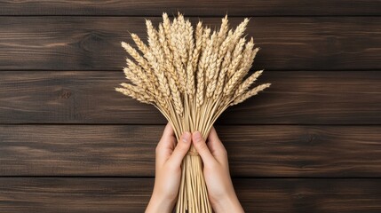 Wall Mural - Hand holding a bundle of freshly harvested wheat against a rustic wooden backdrop, natural textures and details 