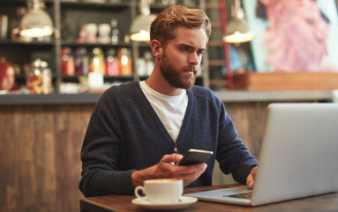 Poster - Man, phone and serious with laptop in coffee shop for ecommerce, online banking and lunch break. Remote work, freelancer and customer with smartphone for multitasking, relax and networking in bistro