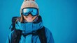© Thanthara - Portrait of snowboarder smiling happy young woman in blue suit goggles mask, hat, ski padded jacket.