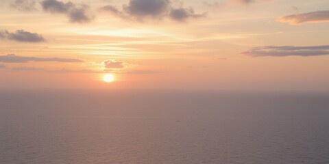 Canvas Print - A golden sunset over the ocean with a few clouds.