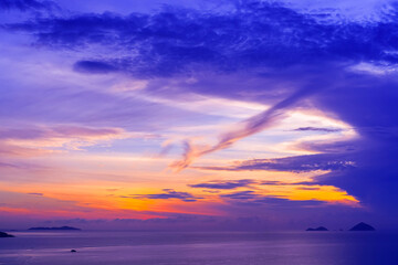Wall Mural - General view of horizon over ocean in the distance there are islands and mountains with lilac tinted clouds before sunrise early in the morning