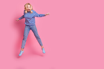 Wall Mural - Full body photo of attractive mature woman falling down look empty space dressed stylish striped clothes isolated on pink color background