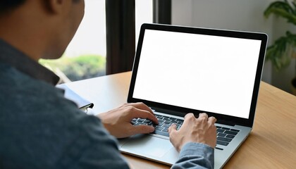 young man using computer laptop in front of an blank white computer screen in home 