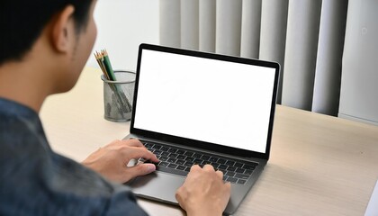 young man using computer laptop in front of an blank white computer screen in home 