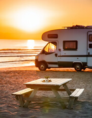 Wall Mural - Wooden table in blurred motorhome camper tent at sunset on the beach , coast near the sea. Cool and relaxing concept. For product display montage or key visual layout design. space for text