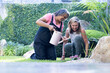 © Wavebreak Media - Watering plants, two senior multiracial female friends gardening together