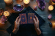 © Alexandra - Fortune teller is reading tarot cards surrounded by crystals and candles on a wooden table