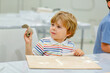 © Irina Schmidt - Little blond boy modeling with clay at master class art in a museum, indoors. Creative leisure for kids in kindergarden and at home, indoors.