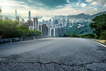 Empty asphalt road and modern city skyline with mountains in the background.