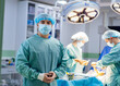 © Vadim - A man in a blue surgical mask stands in front of a surgical team. Scene is serious and focused, as the man is likely a surgeon or a medical professional preparing for a procedure