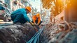 © keks20034 - Workers in uniforms and helmets lay fiber optic cables for internet in the city