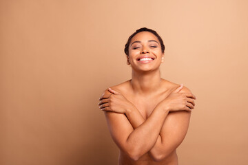 Poster - Photo of gorgeous cheerful woman hugging self closed eyes naked shoulders isolated on beige pastel color background