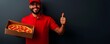 © Chanagun - A cheerful delivery person in a red uniform holds a pizza box and gives a thumbs up against a dark background.
