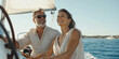 © NILSEN Studio - A mature couple enjoys a sunny day sailing, both smiling brightly with the clear blue sea and horizon in the background.