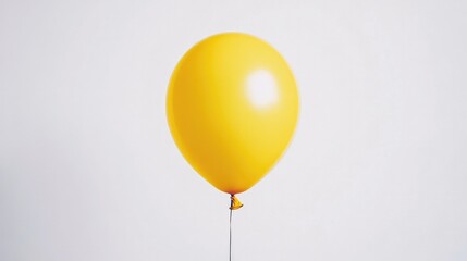 A bright yellow balloon floating freely against a white background, bringing a sense of happiness and simplicity