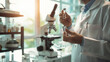 © ki - Scientist holding experimental drug vial in laboratory, conducting medical research with microscope and equipment in background, shallow depth of field, symbolizing drug trials and scientific discover