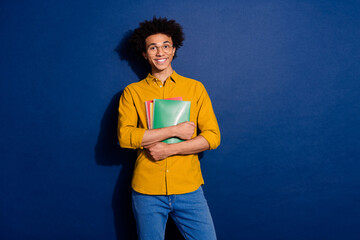 Portrait of nice young man hold book empty space ad wear yellow shirt isolated on dark blue color background