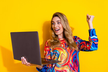 Poster - Photo portrait of pretty young girl hold netbook winning wear trendy colorful outfit isolated on yellow color background