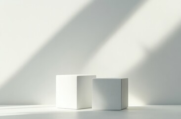 Two white cubes on a white surface with a long shadow falling on them.