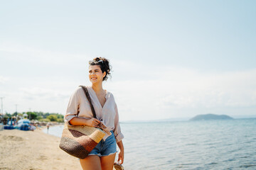 Wall Mural - Young caucasian woman is going to the beach with straw bag