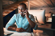 © peopleimages.com - Night, phone call and man at desk with computer, smile and networking for online connectivity at digital agency. Smartphone, discussion and designer on mobile app for contact, chat and dark office