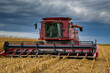 © ProArt Studios - A giant combine harvests in a corn field. Agriculture industry and harvesting concept.