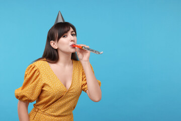 Poster - Woman in party hat with blower on light blue background, space for text