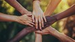 © nurman - Close up of hands of diverse people stacked on top of each other, symbolizing teamwork and unity.