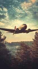 A vintage airplane flying over a forest.