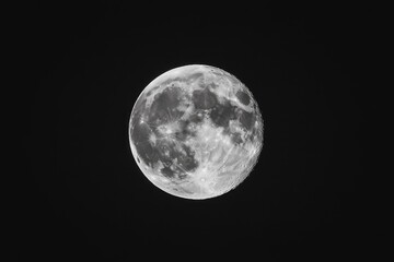 a full moon with craters and detail on a dark, starry night.