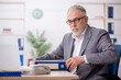 © Elnur - Old male employee working in the office