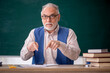 © Elnur - Old male teacher in front of green board