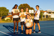 © Austockphoto - five members of a children's mixed netball team posing for a photo