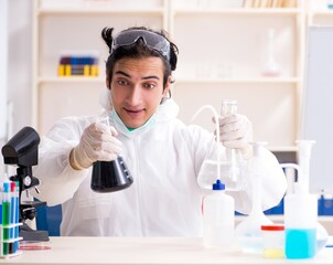 Wall Mural - Young handsome chemist working in the lab