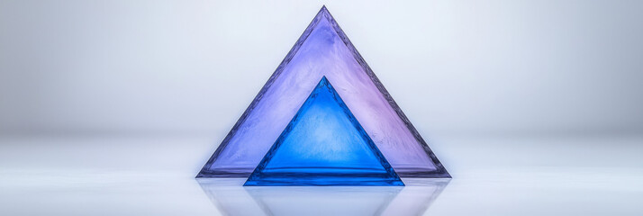 Two glass pyramids, one blue and one purple, on a white background.