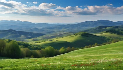 Breathtaking spring panorama of mountainous countryside with lush grassy fields and rolling hills in serene rural scenery