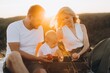 © anatoliycherkas - Happy Family Enjoying a Relaxing Outdoor Picnic During Golden Sunset Together
