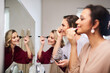 © Malambo/peopleimages.com - Woman, brush and mirror for makeup, cosmetics and beauty with facial transformation and foundation. Female person, tools and bridesmaids in salon for face, aesthetic and clear smooth skin texture