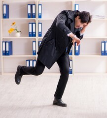 Poster - Young male employee in the office in time management concept