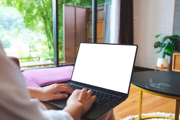 Mockup image of a woman using and typing on computer laptop with blank desktop screen at home