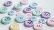 © Bonsales - Colorful, pastel buttons scattered on white background, various sizes and shapes, soft light, crafting concept